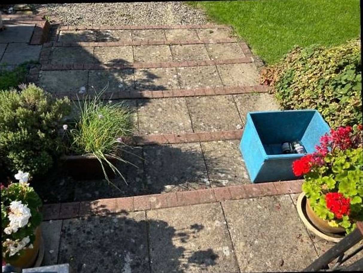 A patio with tired, dirt-stained slabs